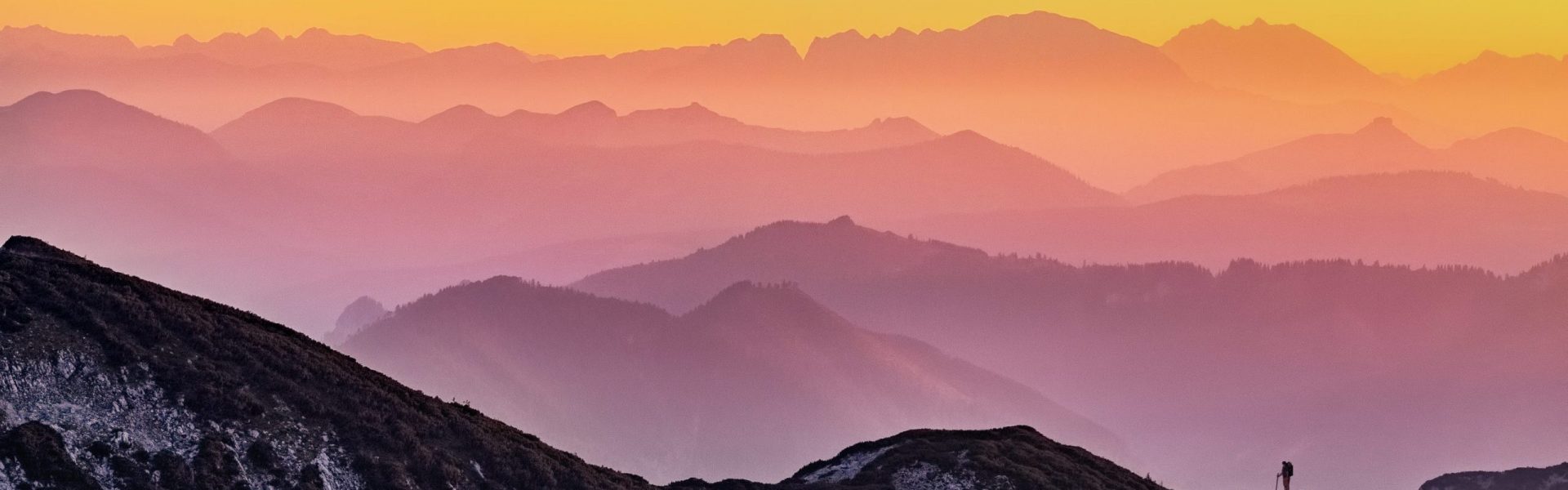 rainbow colored sunset over misty mountains